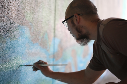 Dave Young Kim painting a mural