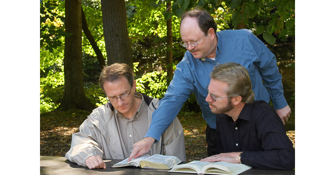 Three men in a Bible study session