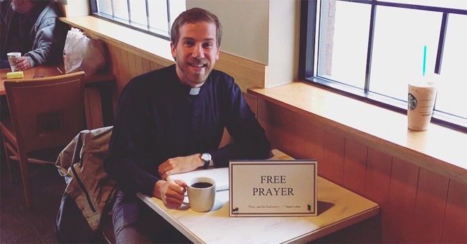 Thomas Rupert in a coffee shop with a "Free Prayer" sign on his table