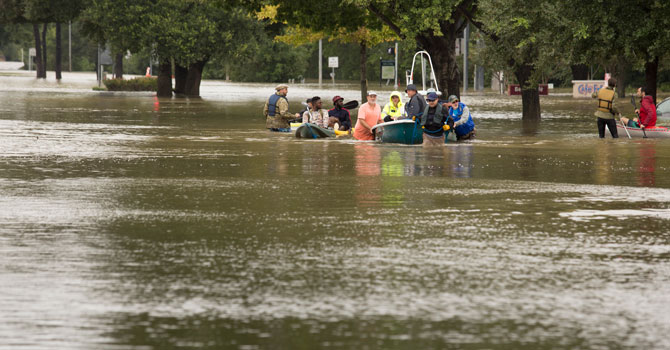Volunteers evacuate people in a boat from a flooded neighborhood in Houston.