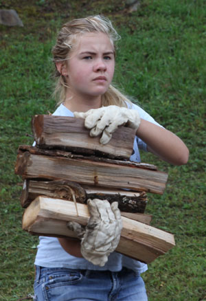 Girl with firewood in her arms