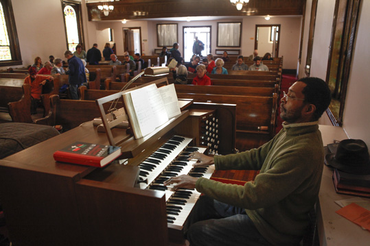 Staff organist Edward Clarence Smith plays as the congregation gathers to worship.