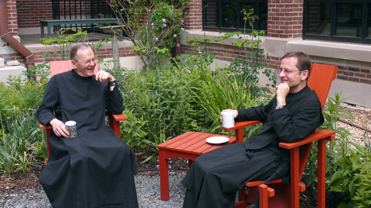 Two monks drinking coffee in the garden